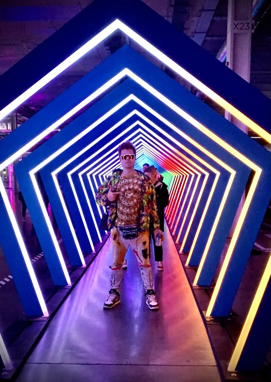 Gary Lachance in a neon tunnel wearing sunglasses