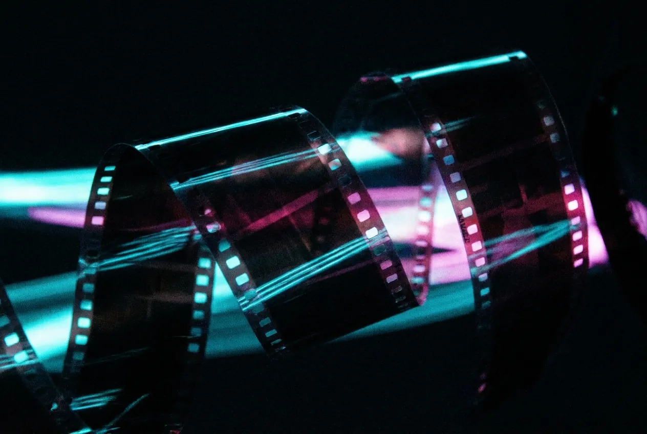 Abstract art: curling strips of film negative with neon light leaks